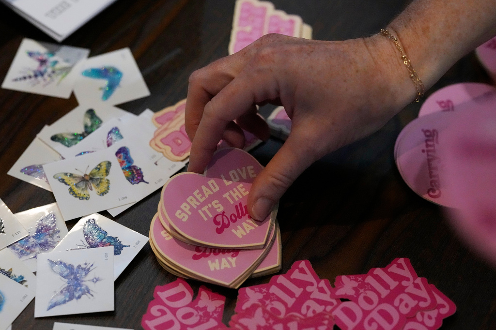 Stickers are seen during a Dolly Parton Day event to honor the late country music artist, Friday, Sept. 25, 2026, in Nashville, Tenn. (AP Photo/George Walker IV)