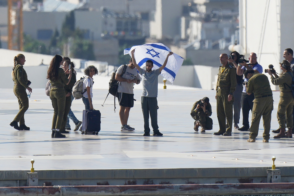 Nimrod Cohen, an Israeli hostage released from the Gaza Strip holds an Israeli flag after coming off a helicopter at the Ichilov Hospital, in Tel Aviv, Israel, Monday, Oct. 13, 2025. (AP Photo/Ohad Zwigenberg)