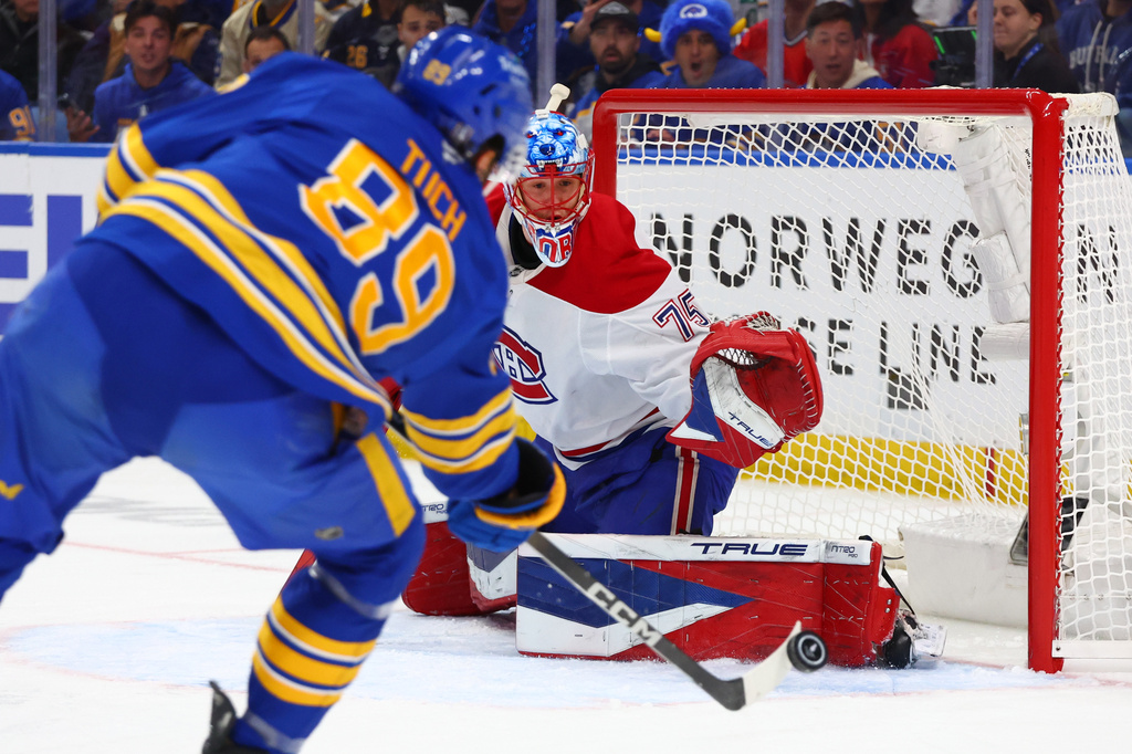 Montreal Canadiens goaltender Jakub Dobes, right, watches the puck shot by Buffalo Sabres right wing Alex Tuch (89) during the first period in Game 1 of a second-round NHL hockey Stanley Cup playoff series, Wednesday, May 6, 2026, in Buffalo, N.Y. (AP Photo/Jeffrey T. Barnes)