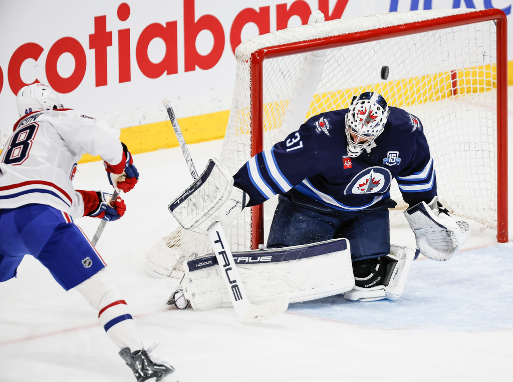 Montreal Canadiens' Lane Hutson (48) scores on Winnipeg Jets goaltender Connor Hellebuyck (37) during the second period of an NHL game in Winnipeg, Wednesday, Feb. 4, 2026. (John Woods/The Canadian Press via AP)