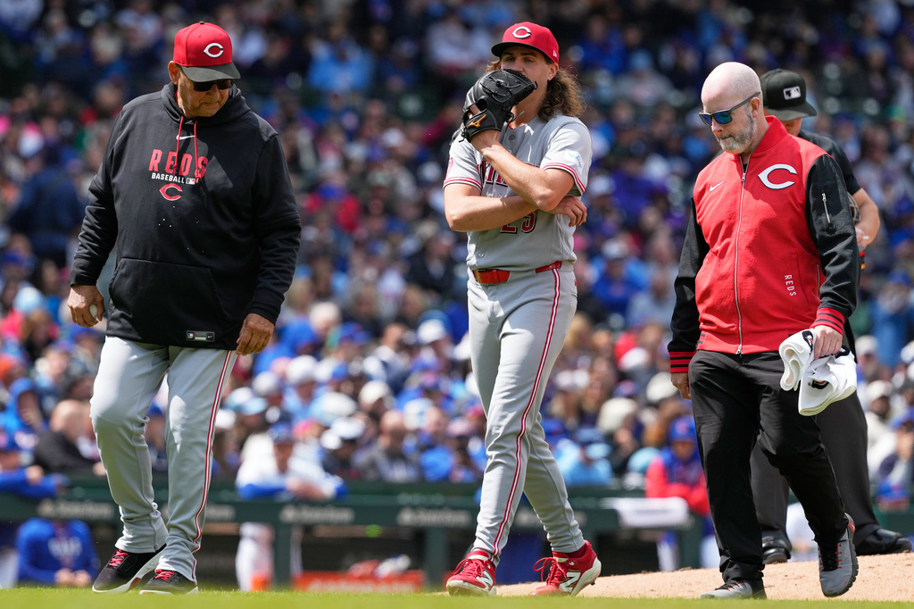 Cincinnati Reds starting pitcher Rhett Lowder, center, leaves with manager Terry Francona, left, and a team trainer after an injury during the fourth inning of a baseball game against the Chicago Cubs in Chicago, Thursday, May 7, 2026. (AP Photo/Nam Y. Huh)