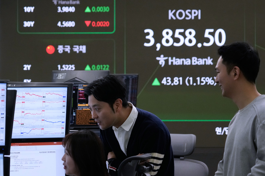 Currency traders watch monitors near a screen showing the Korea Composite Stock Price Index (KOSPI) at the foreign exchange dealing room of the Hana Bank headquarters in Seoul, South Korea, Tuesday, Oct. 21, 2025. (AP Photo/Ahn Young-joon)