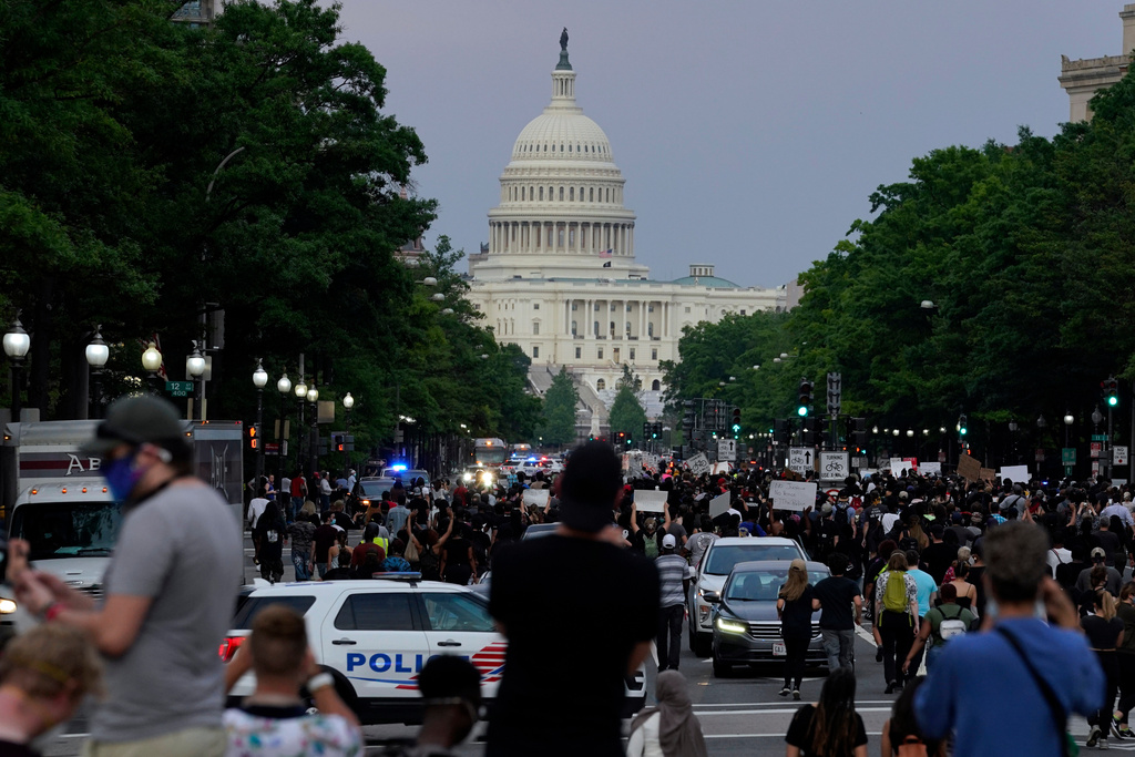 FILE - Demonstrators walk along Pennsylvania Avenue as they protest the death of George Floyd, May 29, 2020, in Washington. (AP Photo/Evan Vucci, File)