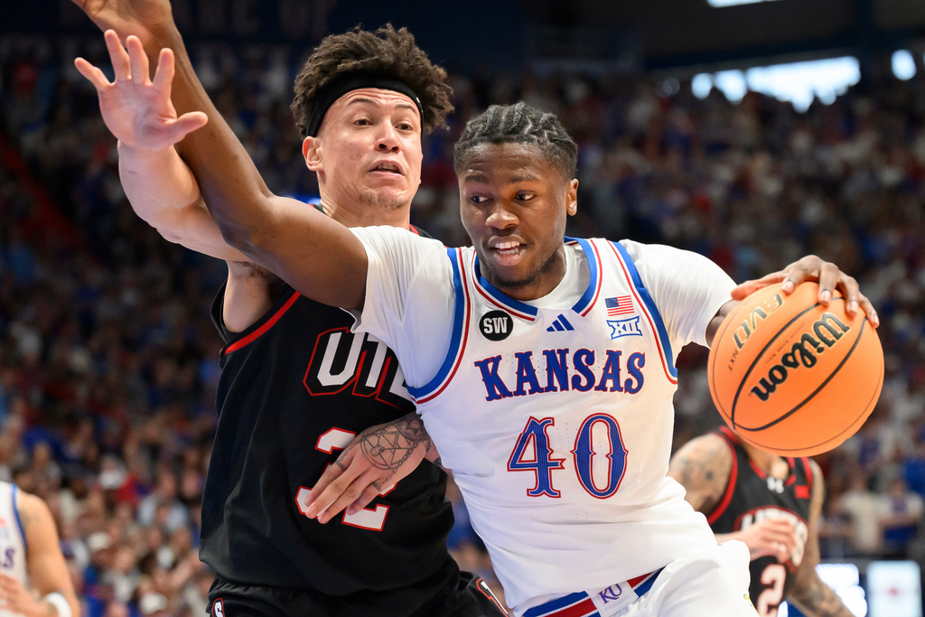 Kansas forward Flory Bidunga (40) drives around Utah forward James Okonkwo (32) during the first half of an NCAA college basketball game in Lawrence, Kan., Saturday, Feb. 7, 2026. (AP Photo/Reed Hoffmann)