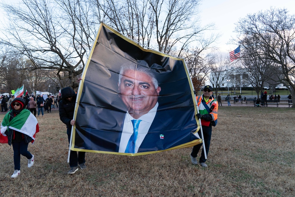 Activists carrying a photograph of Reza Pahlavi take part in a rally supporting protesters in Iran at Lafayette Park, across from the White House, in Washington, Sunday, Jan. 11, 2026. (AP Photo/Jose Luis Magana)