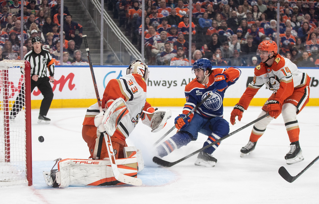 Anaheim Ducks' goalie Ville Husso (33) is scored on as Edmonton Oilers' Matt Savoie (22) and Ducks' Drew Helleson (14) watch the puck go in the net during the second period of an NHL hockey game in Edmonton on Monday, Jan. 26, 2026. (Jason Franson/The Canadian Press via AP)