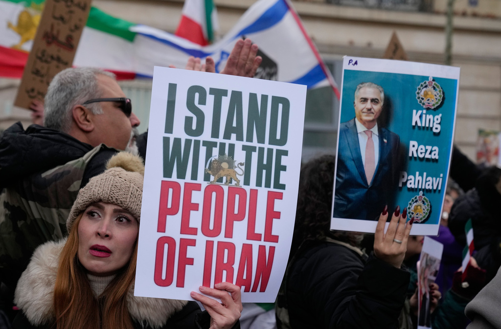 FILE - Protesters hold placards during a rally in support of the nationwide mass demonstrations in Iran against the government in Paris, Jan. 11, 2026. (AP Photo/Michel Euler, File)