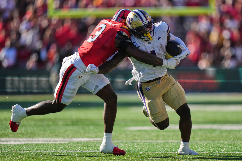 Washington running back Jonah Coleman (1) is tackled by Maryland linebacker Trey Reddick (3) during the first half of an NCAA college football game, Saturday, Oct. 4, 2025, in College Park, Md. (AP Photo/Stephanie Scarbrough)