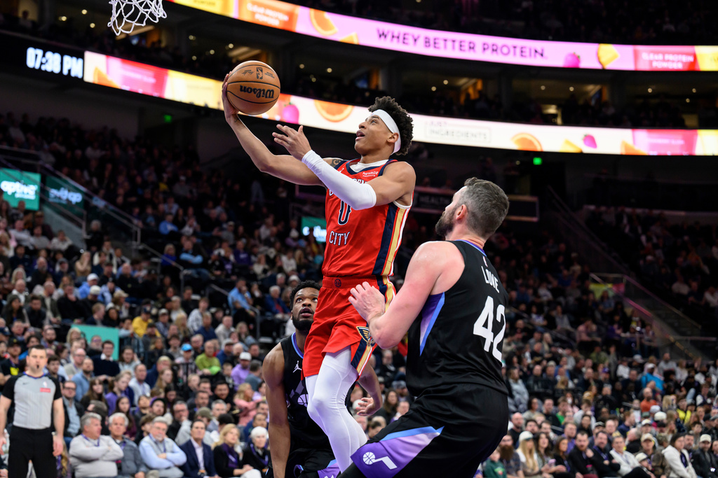 New Orleans Pelicans guard Jeremiah Fears (0) goes to the basket for a layup past the defense of Utah Jazz forward Kevin Love (42) during the first half of an NBA basketball game, Thursday, Feb. 26, 2026, in Salt Lake City. (AP Photo/Tyler Tate)