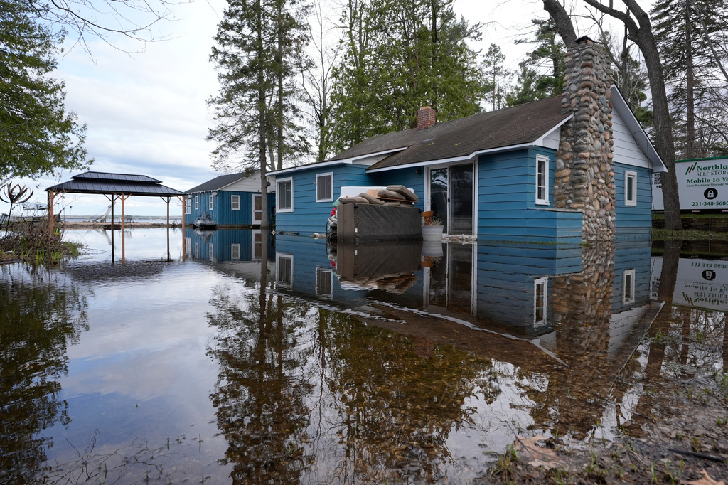 A home is surrounded by water from recent floods at Black Lake on Wednesday, April 29, 2026, in Grant Township, Mich. (AP Photo/Paul Sancya)
