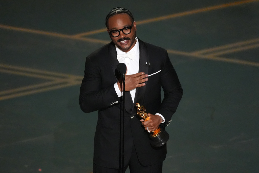 Ryan Coogler accepts the award for writing (original screenplay) for "Sinners" during the Oscars on Sunday, March 15, 2026, at the Dolby Theatre in Los Angeles. (AP Photo/Chris Pizzello)