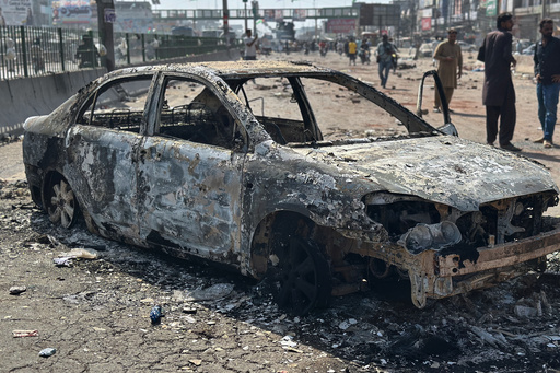 Local residents stand by burnt vehicles after police in Pakistan clashed with thousands of protesters during a march in support of Palestinians, in Muridke near Lahore, Pakistan, Monday, Oct. 13, 2025. (AP Photo/Jahanzeb Khan) Local residents stand by burnt vehicles after police in Pakistan clashed with thousands of protesters during a march in support of Palestinians, in Muridke near Lahore, Pakistan, Monday, Oct. 13, 2025. (AP Photo/Jahanzeb Khan)