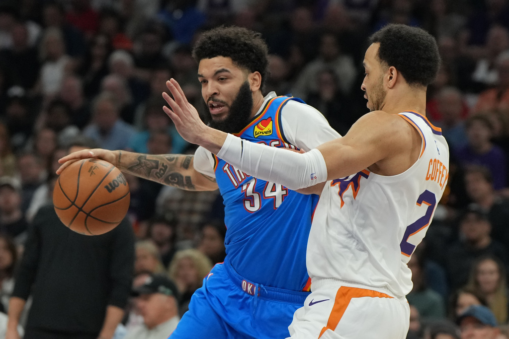 Oklahoma City Thunder guard Kenrich Williams (34) drives on Phoenix Suns guard Amir Coffey during the first half of an NBA basketball game, Wednesday, Feb. 11, 2026, in Phoenix. (AP Photo/Rick Scuteri)