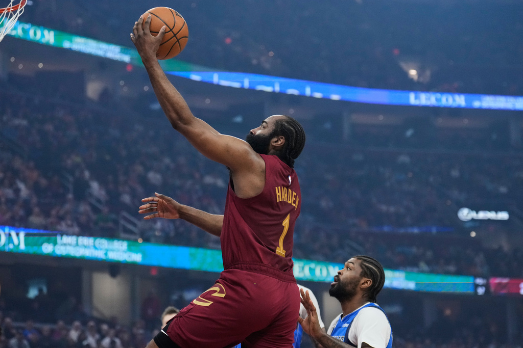 Cleveland Cavaliers guard James Harden (1) goes to the basket past Dallas Mavericks forward Naji Marshall, right, in the first half of an NBA basketball game in Cleveland, Sunday, March 15, 2026. (AP Photo/Sue Ogrocki)