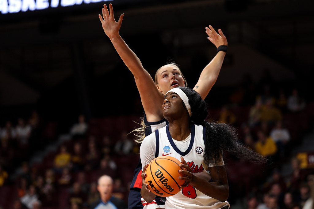 Mississippi forward Latasha Lattimore, front, drives toward the basket as Gonzaga forward Jaiden Haile, top, defends during the first half in the first round of the NCAA college basketball tournament, Friday, March 20, 2026, in Minneapolis, Minn. (AP Photo/Matt Krohn)