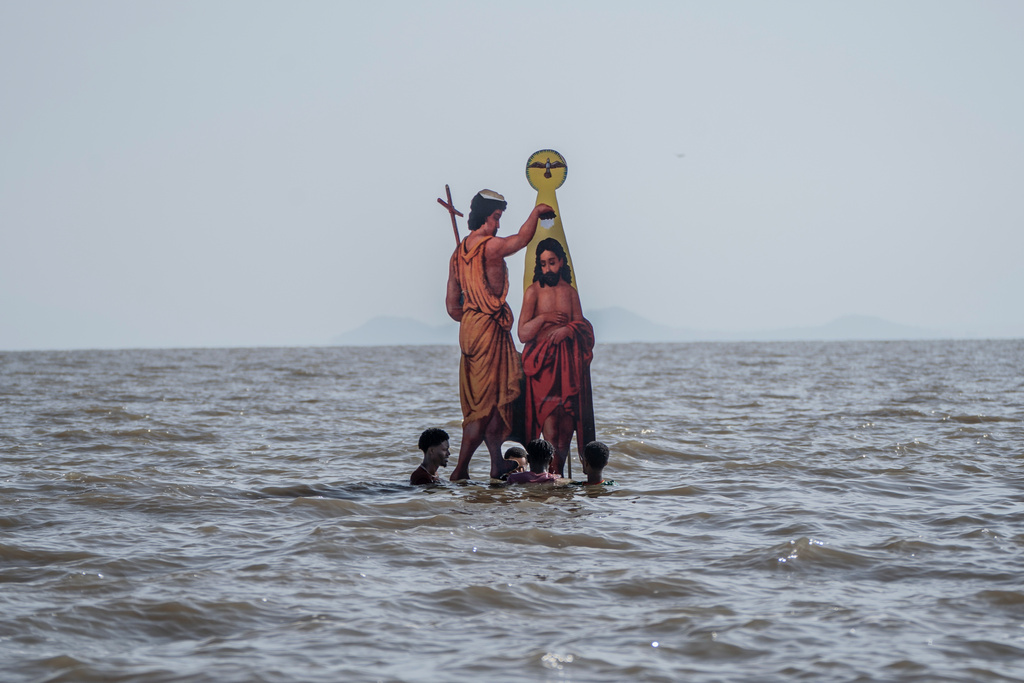 Ethiopian Orthodox devotees place an icon of John the Baptist baptizing Jesus, during the celebration of the Ethiopian Epiphany on the shore of lake Dembel, in Batu, Ethiopia, Monday, Jan. 19, 2026. (AP Photo/Amanuel Sileshi)
