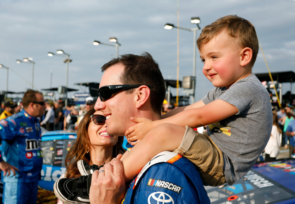 FILE - Kyle Busch carries his son, Brexton, as his wife, Samantha, left, watches before the NASCAR Cup Series auto race at Kansas Speedway in Kansas City, Kan., May 12, 2018. (AP Photo/Colin E. Braley, File)