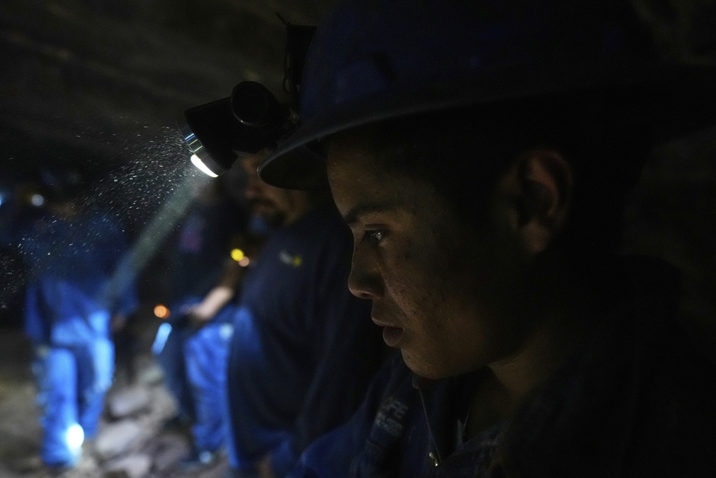 Workers shine headlamps on their colleagues as they emerge from one of the caverns of the mercury mine in San Joaquin, Mexico, Tuesday, Aug. 19, 2025. (AP Photo/Fernando Llano)