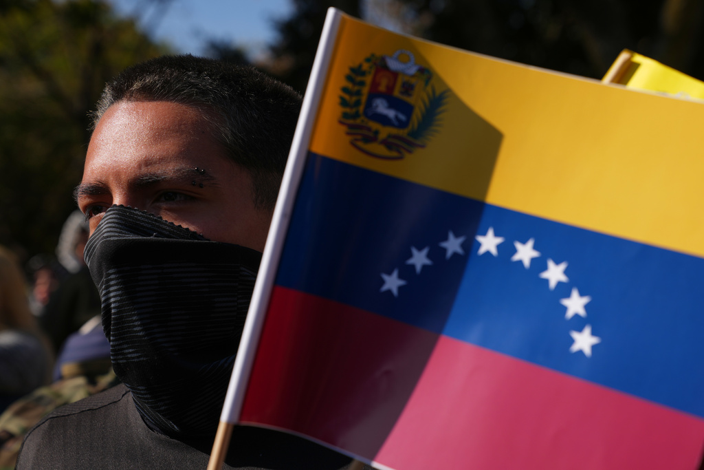 A person holding a Venezuelan national flag protests outside the U.S. Embassy against the capture of President Nicolas Maduro, in Mexico City, Saturday, Jan. 3, 2026. (AP Photo/Marco Ugarte)