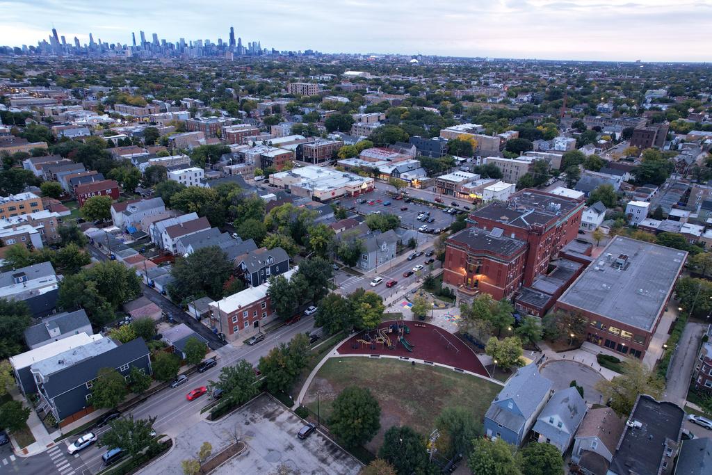 The brick buildings of Funston Elementary School, right, stands in Chicago's Logan Square neighborhood, with downtown in the background, Wednesday, Oct. 15, 2025. (AP Photo/Rebecca Blackwell)