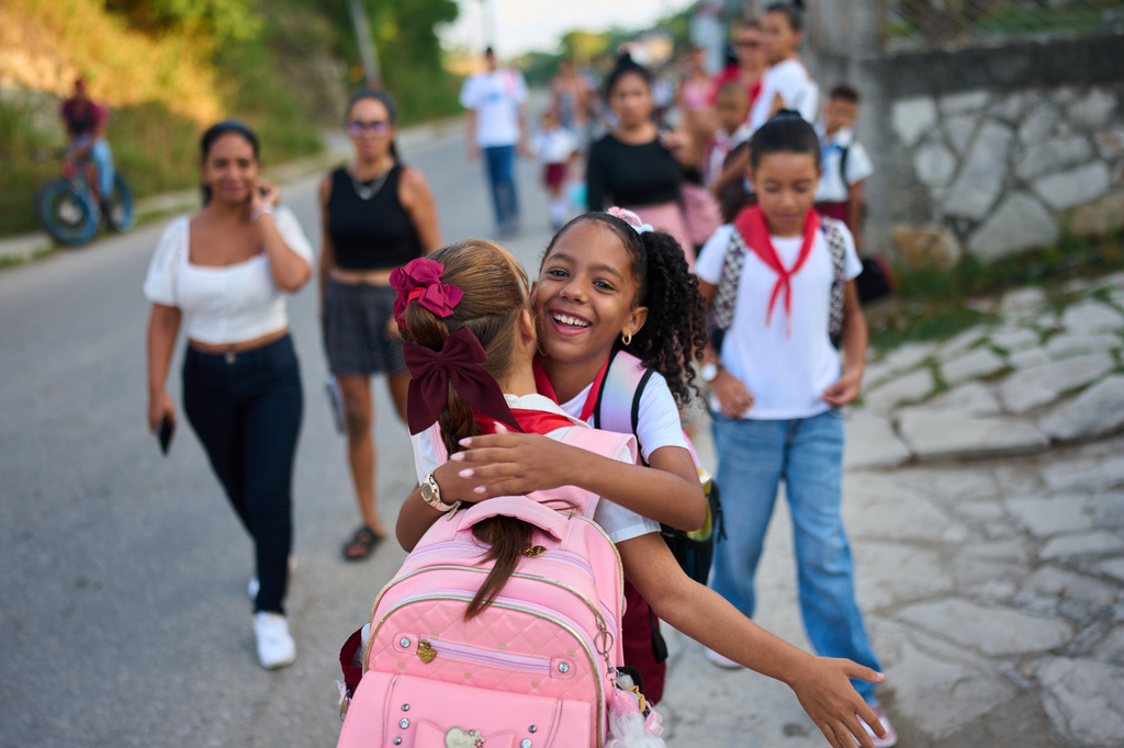 Girls hug as they arrive to school for their first day back to classes in Minas, Cuba's Havana province, Tuesday, Sept. 1, 2026. (AP Photo/Ramon Espinosa)