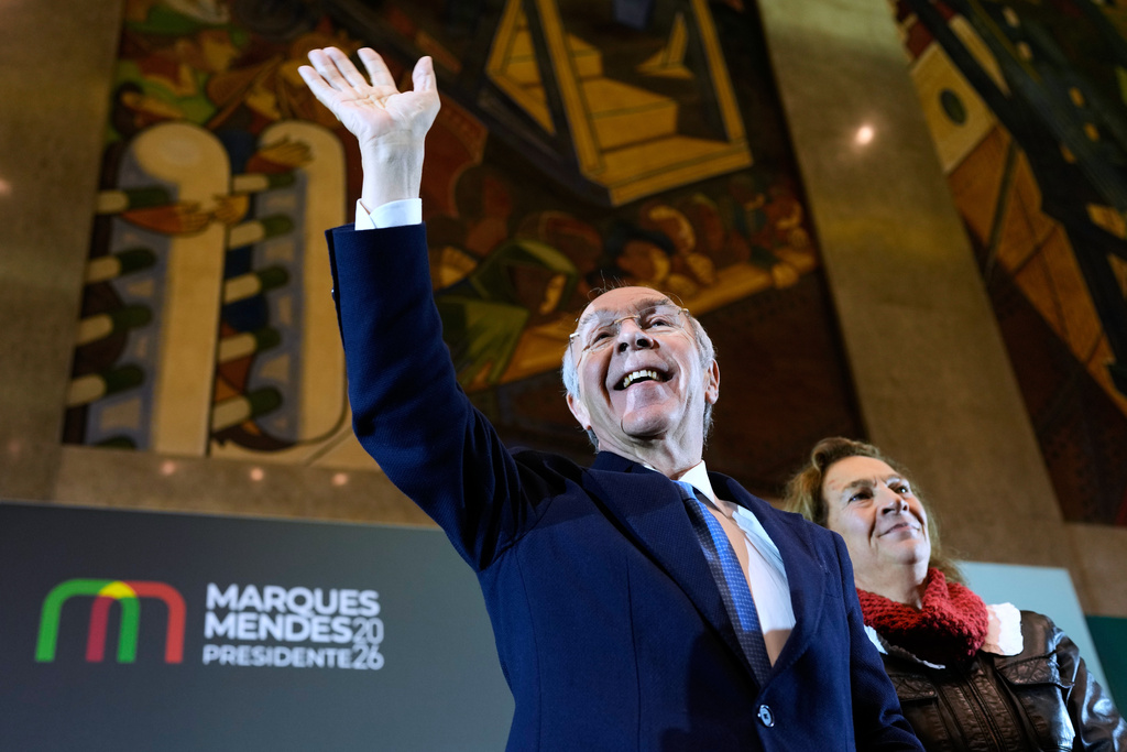 Presidential candidate Luis Marques Mendes, from the center-right Social Democratic Party, with his wife Rosa Sofia Salazar, gestures to supporters while campaigning for Sunday's presidential election, in Lisbon, Portugal, Friday, Jan. 16, 2026. (AP Photo/Armando Franca)