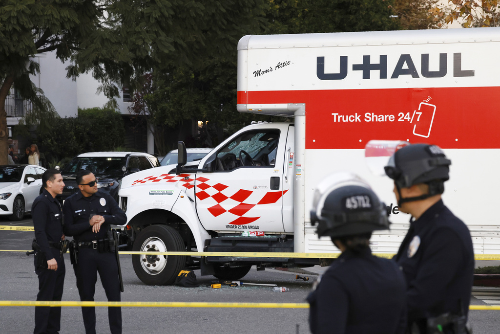 A U-Haul truck, which was driven into a group of protesters, is surrounded by LAPD officers after the incident on Jan. 11, 2026, in the Westwood section of Los Angeles. (Kayla Bartkowski/Los Angeles Times via AP)