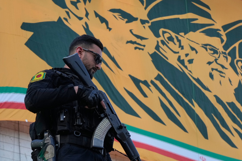 A police officer stands guard in front of a banner with portraits of the late Iranian revolutionary founder Ayatollah Khomeini, left, and late Supreme Leader Ayatollah Ali Khamenei in a state-organised rally celebrating the birthday of Imam Reza, the 8th Shiite Muslims' Imam, and supporting the supreme leader, in Tehran, Iran, Wednesday, April 29, 2026. (AP Photo/Vahid Salemi)