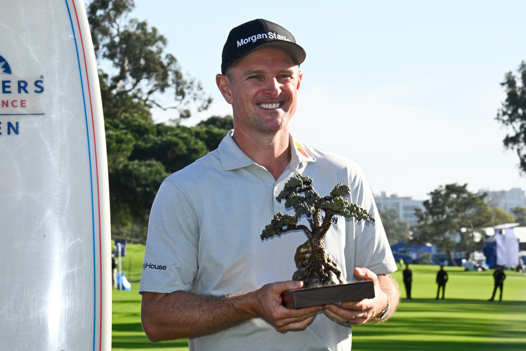 Justin Rose, of England, holds the winner's trophy at the Farmers Insurance Open golf tournament Sunday, Feb. 1, 2026, at Torrey Pines in San Diego. (AP Photo/Denis Poroy)