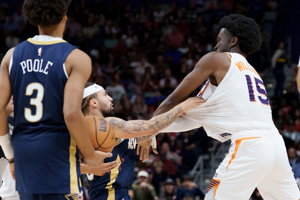 New Orleans Pelicans guard Jose Alvarado, left, and Phoenix Suns center Mark Williams (15) get into a scrum during the third quarter before both were ejected during an NBA basketball game in New Orleans, Saturday, Dec. 27, 2025. (AP Photo/Matthew Hinton)