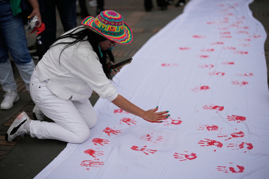 A sheet is covered by handprints at an event marking Red Hand Day, also known as the International Day against the Use of Child Soldiers, in Bogota, Colombia, where illegal armed groups recruit children, Thursday, Feb. 12, 2026. (AP Photo/Fernando Vergara)
