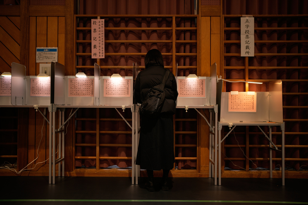 A voter fills in a ballot in the lower house election at a polling station Sunday, Feb. 8, 2026, in Tokyo. (AP Photo/Louise Delmotte)