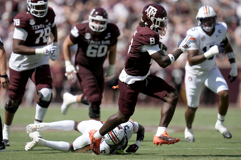 Texas A&M running back Le'Veon Moss (8) steps out a tackle by Auburn safety Jahquez Robinson (5) for a first yard run inside the 5 yard line during the first quarter of an NCAA college football game Saturday, Sept. 27, 2025, in College Station, Texas. (AP Photo/Sam Craft)