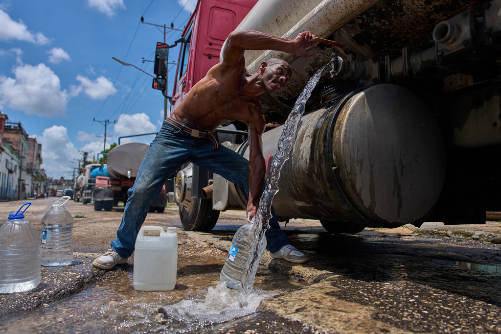 A man fills water jugs from a tanker truck in Havana, Thursday, May 28, 2026. (AP Photo/Ramon Espinosa)