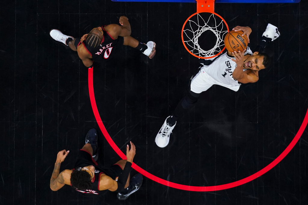 San Antonio Spurs' Victor Wembanyama, right, dunks the ball as Philadelphia 76ers' Tyrese Maxey, centers nd Dom Barlow, left, looks on during the second half of an NBA basketball game, Tuesday, March 3, 2026, in Philadelphia. (AP Photo/Chris Szagola)