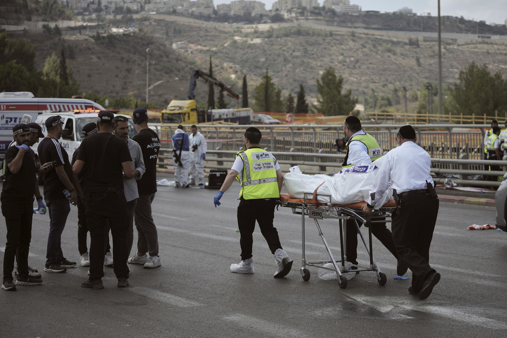 Israeli Zaka rescue and recovery team carry the body of a victim at the scene of shooting attack carried out by two Palestinian gunmen, in which several people were killed and others injured at a bus stop in Jerusalem, Monday, Sept. 8, 2025. (AP Photo/Mahmoud Illean)