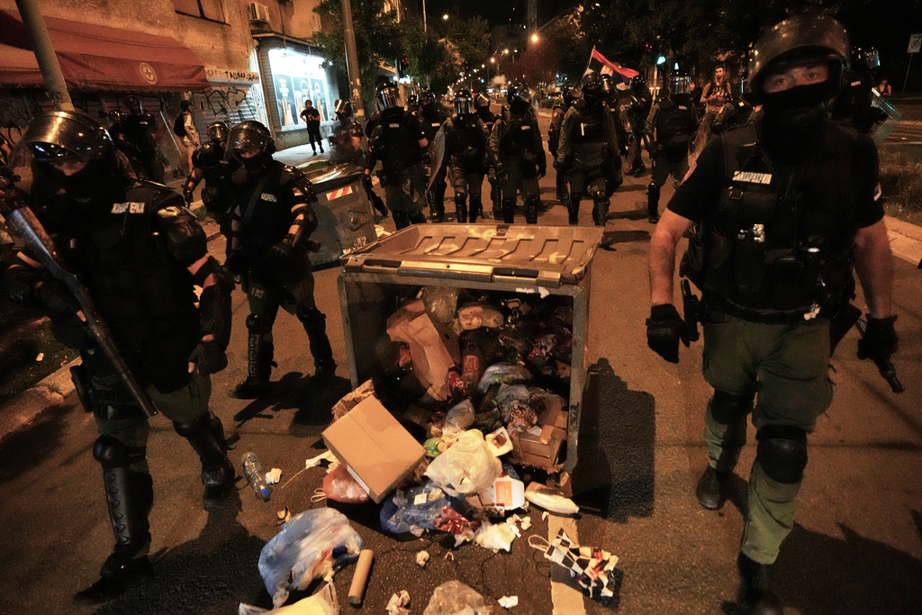Serbian gendarmerie officers chase protesters during an anti-government protest in Belgrade, Serbia, Monday, Aug. 18, 2025. (AP Photo/Darko Vojinovic)
