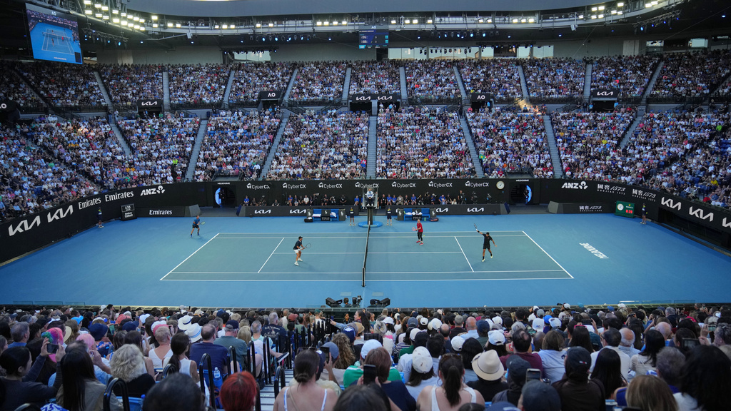 Andre Agassi of the United States and Roger Federer of Switzerland play doubles against Lleyton Hewitt and Pat Rafter of Australia during the Opening Ceremony for the Australian Open tennis championship in Melbourne, Australia, Saturday, Jan. 17, 2026. (AP Photo/Dita Alangkara)