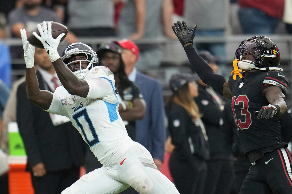 Tennessee Titans wide receiver Calvin Ridley (0) makes a catch past Arizona Cardinals cornerback Kei'Trel Clark (13) during the second half of an NFL football game Sunday, Oct. 5, 2025, in Glendale, Ariz. (AP Photo/Rick Scuteri)