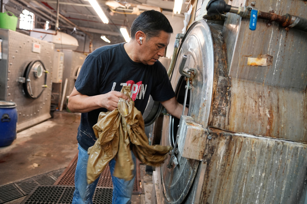 Ruben Revollo inspects some samples after washing them at the BPD Washhouse, a denim processing facility, in Jersey City, N.J., Tuesday, May 5, 2026. (AP Photo/Seth Wenig)