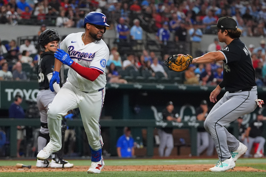 Texas Rangers' Elias Díaz runs from Chicago White Sox first baseman Munetaka Murakami for an out on a sacrifice bunt during the fifth inning of a baseball game, Tuesday, July 21, 2026, in Arlington, Texas. (AP Photo/LM Otero)