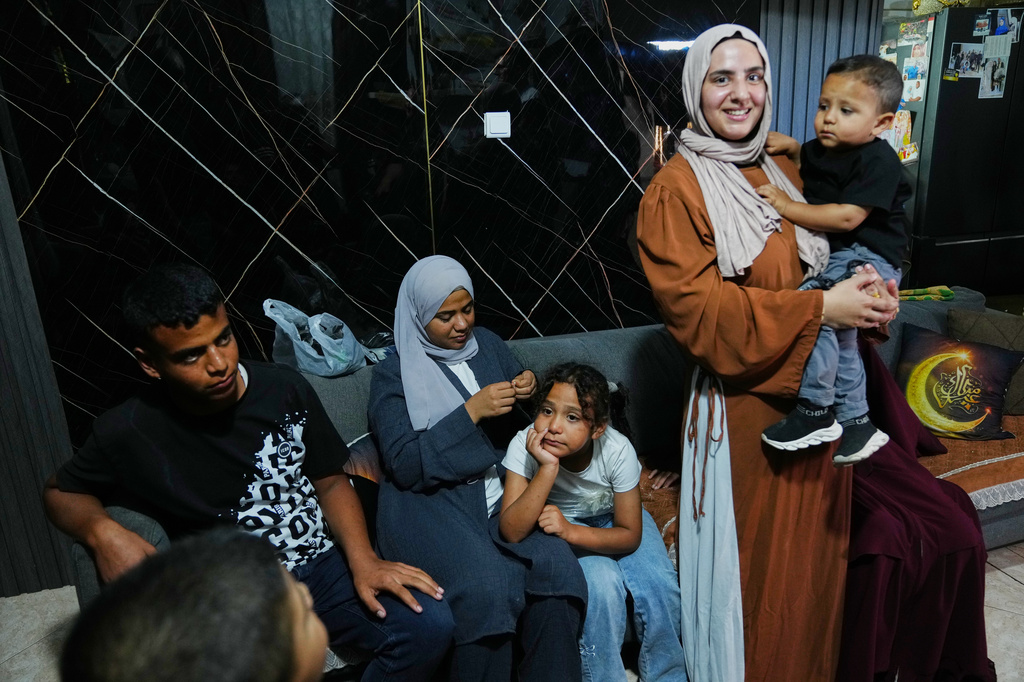 Mais Al-Gharam holds her son as she stands with her siblings from Gaza, who were granted Israeli passports, in her home in Nazareth, Israel, Wednesday, July 8, 2026. (AP Photo/Mahmoud Illean)