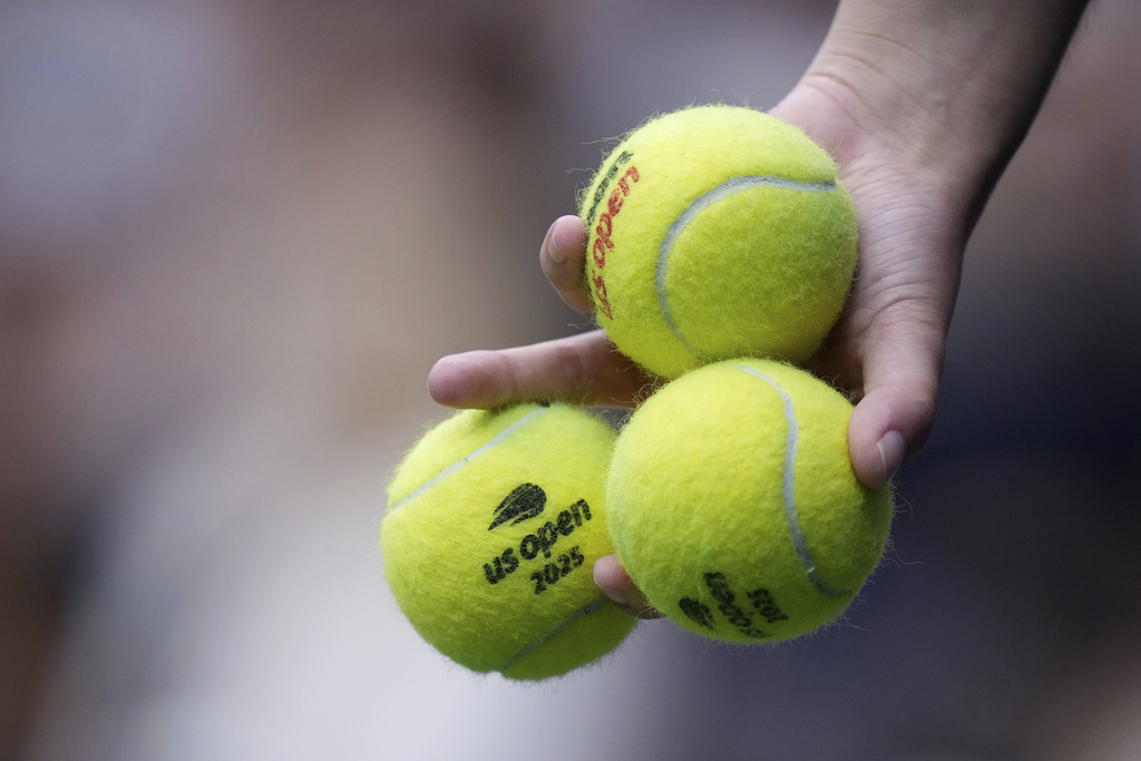 Tennis ball are delivered to Jannik Sinner, of Italy, during the men's singles final of the U.S. Open tennis championships against Carlos Alcaraz, of Spain,, Sunday, Sept. 7, 2025, in New York. (AP Photo/Frank Franklin)