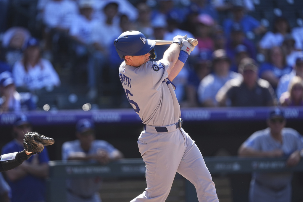 Los Angeles Dodgers' Will Smith singles to drive in a run off Colorado Rockies relief pitcher Luis Peralta in the eighth inning of a baseball game Thursday, Aug. 21, 2025, in Denver. (AP Photo/David Zalubowski)
