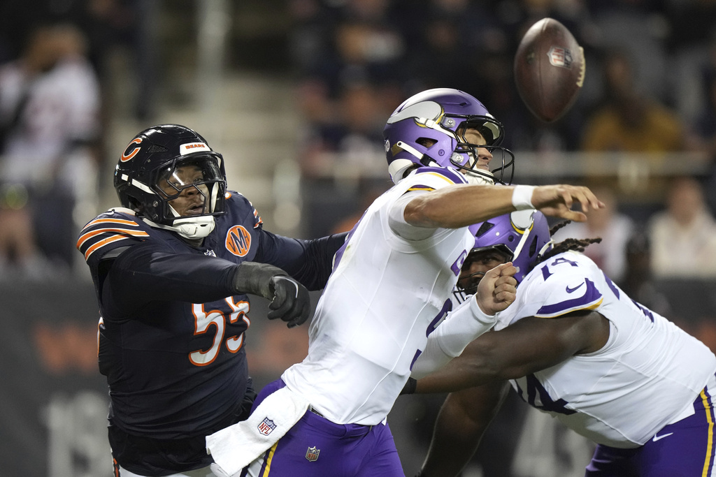 Minnesota Vikings quarterback J.J. McCarthy, right, has his arm hit by Chicago Bears defensive lineman Dayo Odeyingbo (55) while throwing an incomplete pass during the first half of an NFL football game Monday, Sept. 8, 2025, in Chicago. (AP Photo/Nam Y. Huh)