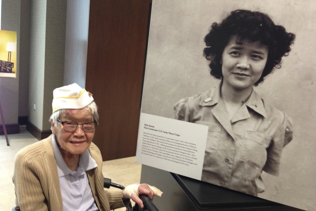 This photo provided by Elaine Yuen shows her mother, Elsie Chin Yuen Seetoo, next to a photo of herself at an exhibit at the Army Historical Foundation in Arlington, Va., in May 2017. (Elaine Yuen via AP)