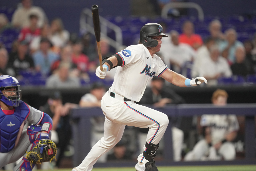 Miami Marlins designated hitter Griffin Conine (18) hits an RBI double against the Texas Rangers in the fourth inning of a baseball game, Wednesday, June 24, 2026, in Miami. (AP Photo/Jim Rassol)