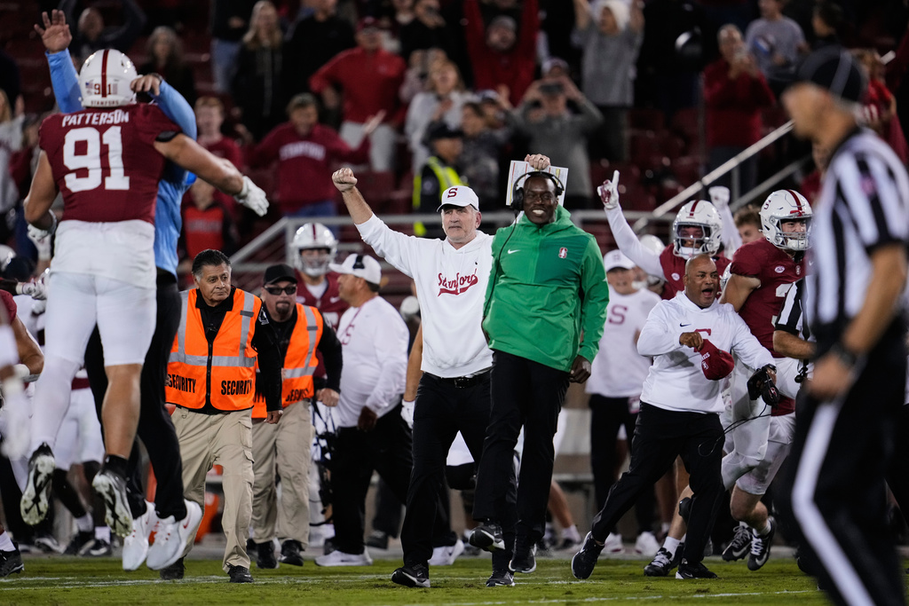 Stanford head coach Frank Reich, center left, celebrates with players and staff after the team's victory over Florida State in an NCAA college football game, Saturday, Oct. 18, 2025, in Stanford, Calif. (AP Photo/Godofredo A. Vásquez)