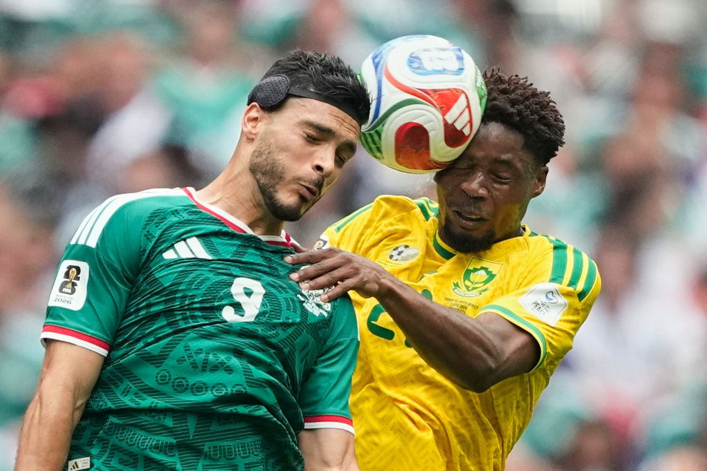 Mexico's Raul Jimenez, left, jumps for the ball with South Africa's Ime Okon during the World Cup Group A soccer match between Mexico and South Africa in Mexico City, Thursday, June 11, 2026. (AP Photo/Natacha Pisarenko)