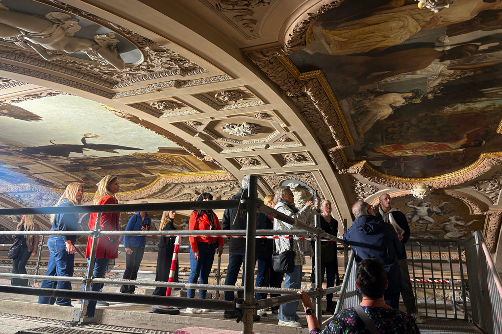 People look at a restored painting of Gustav Klimt during a guided tour of the restoration of the ceiling paintings at the Burgtheater in Vienna, Austria, Monday, April 20, 2026. (AP Photo/Philipp-Moritz Jenne)